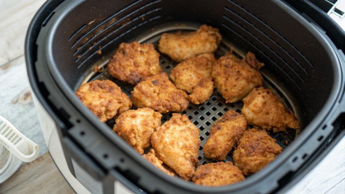 Golden crispy chicken bites inside the air fryer basket
